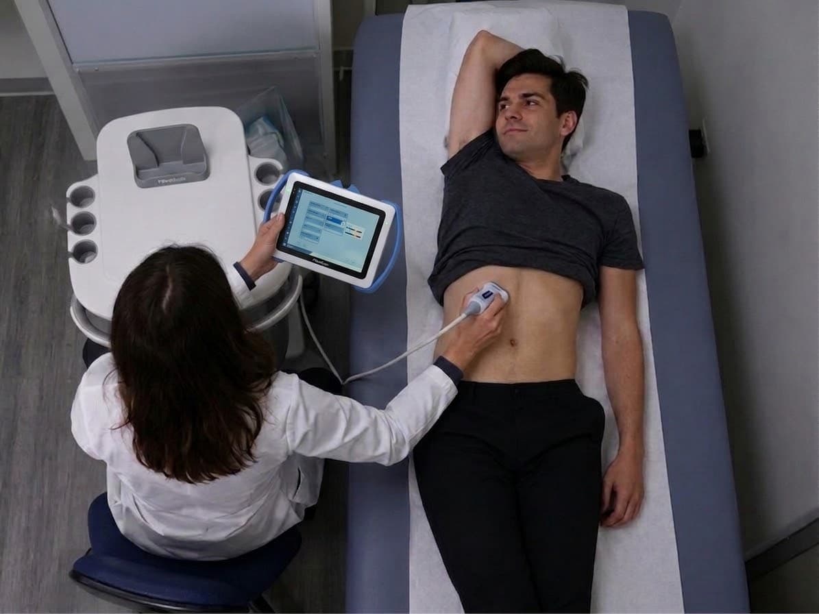 Operador de FibroScan mostrando los resultados del estudio en pantalla a una paciente